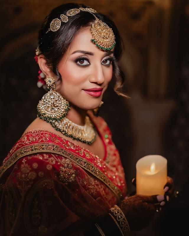 Bride in red with traditional jewellery and candlelight