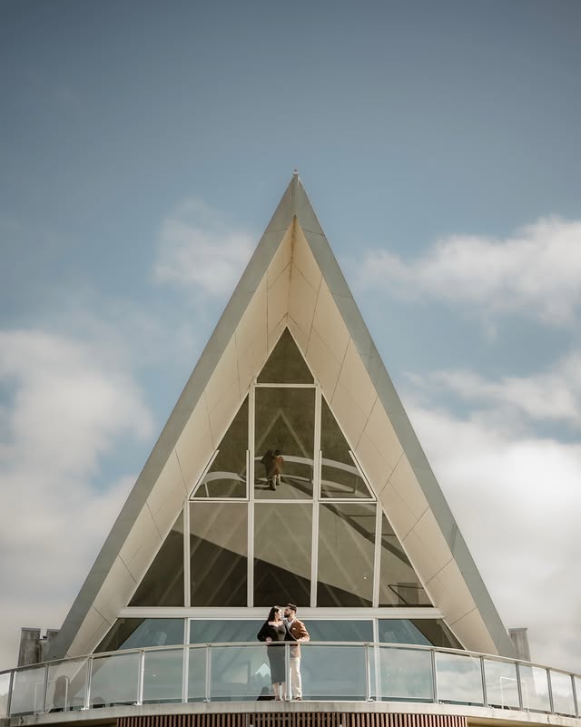 Couple beneath the peak of a modern chapel